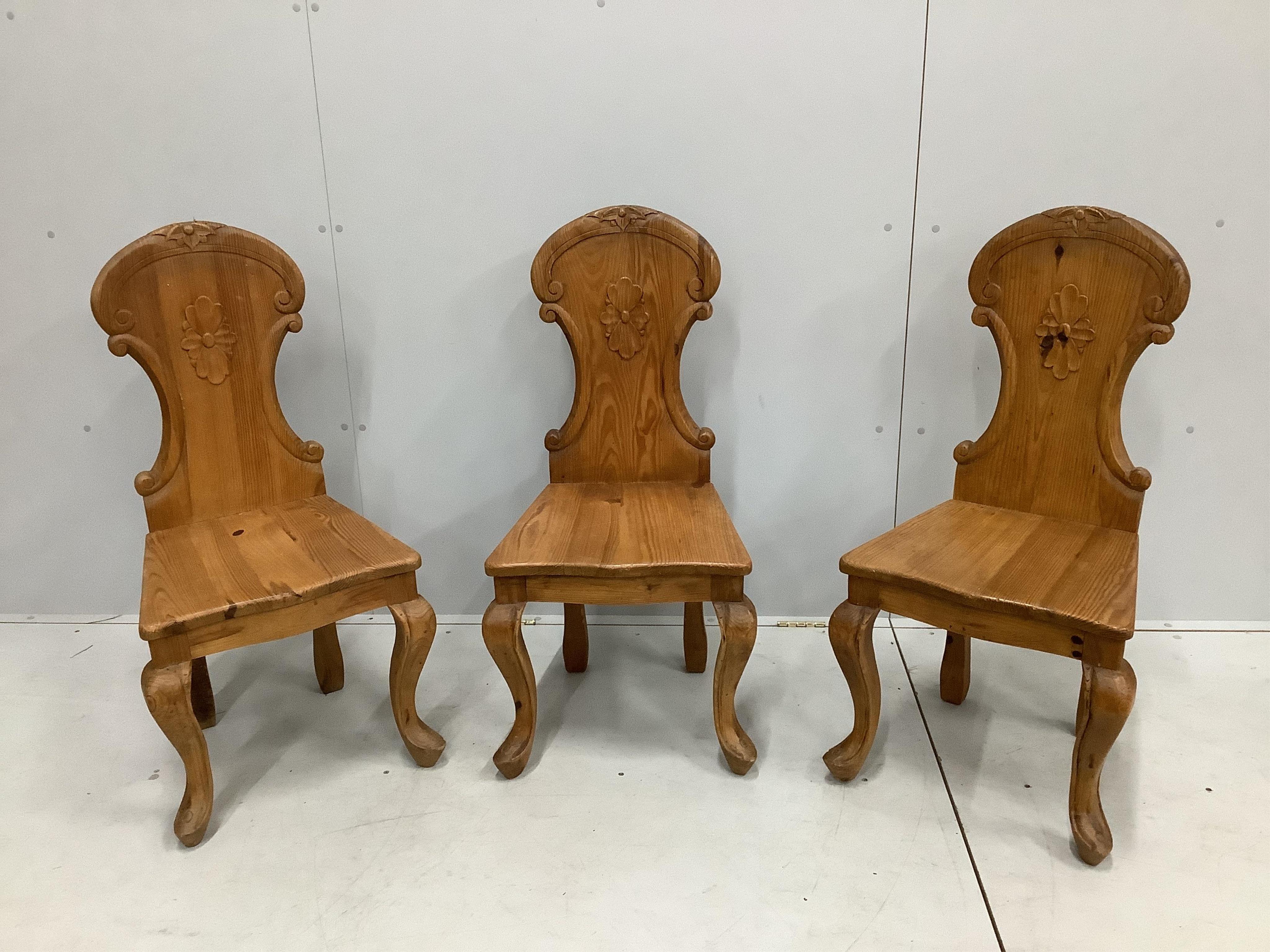 Three Victorian style carved pine hall chairs, height 96cm